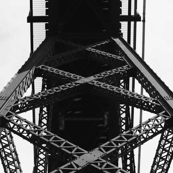 The steel frame of a bridge tower seen from below